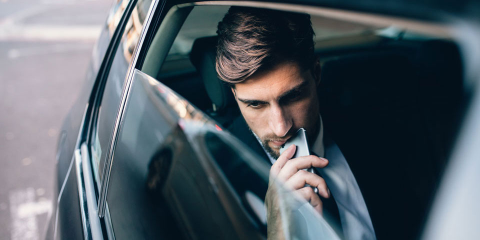 A man in the back of a limo about to drive off for a good evening