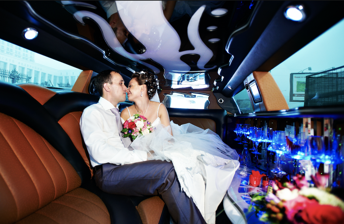 The interior of a wedding limo with a bride and groom. 